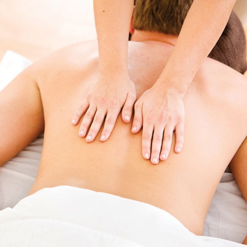 massage therapist massaging male client's back