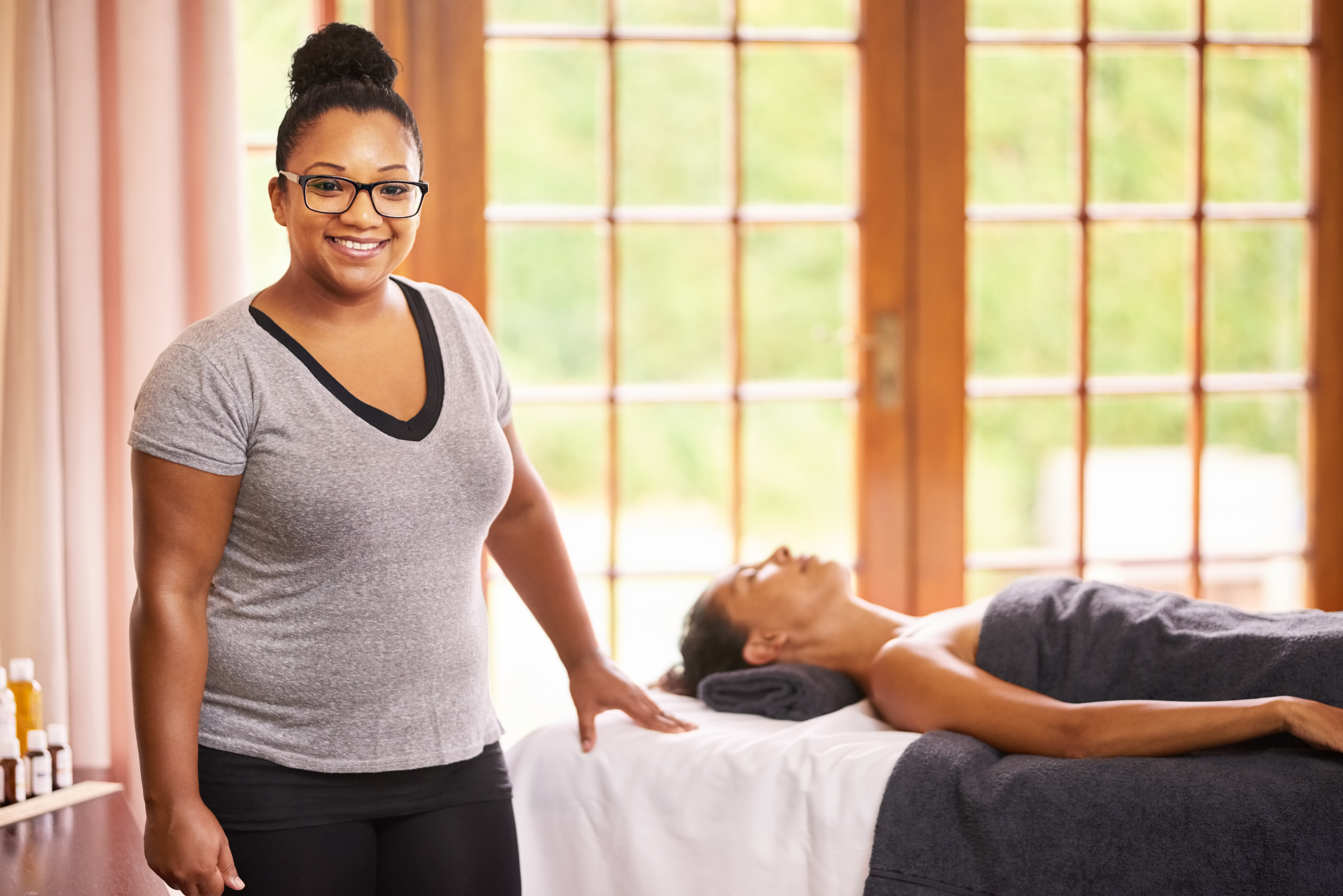 woman smiling next to woman on massage table
