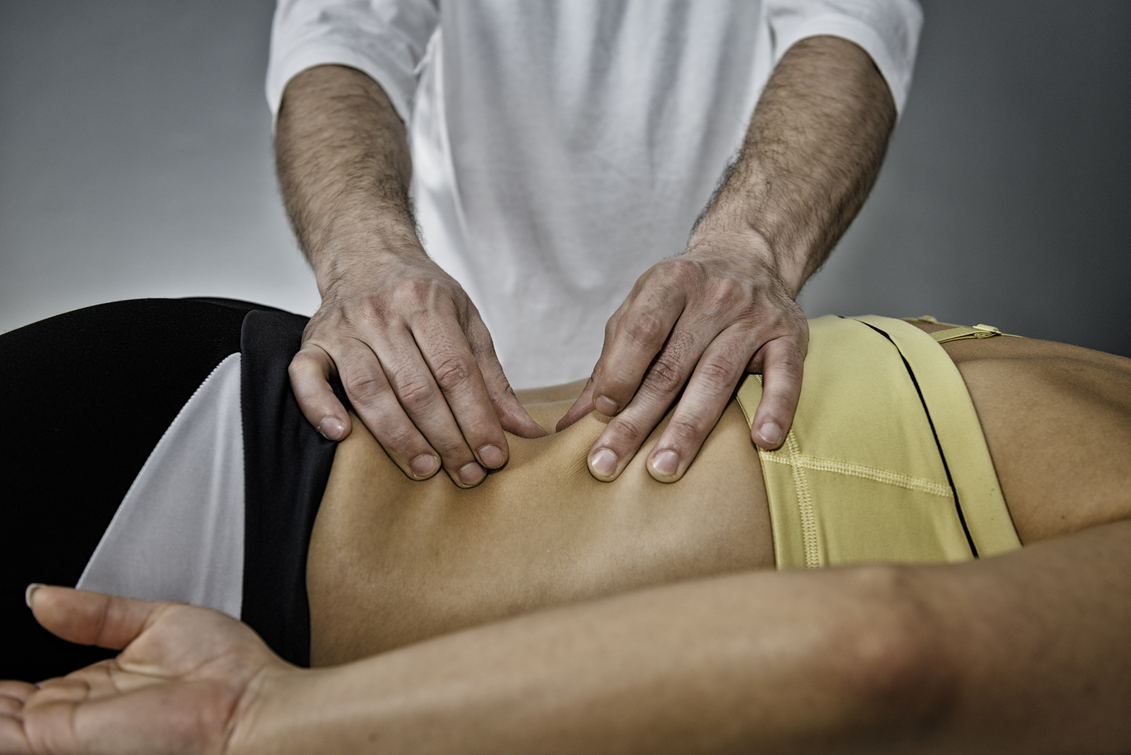 male massage therapist performing fascial therapy on a female client