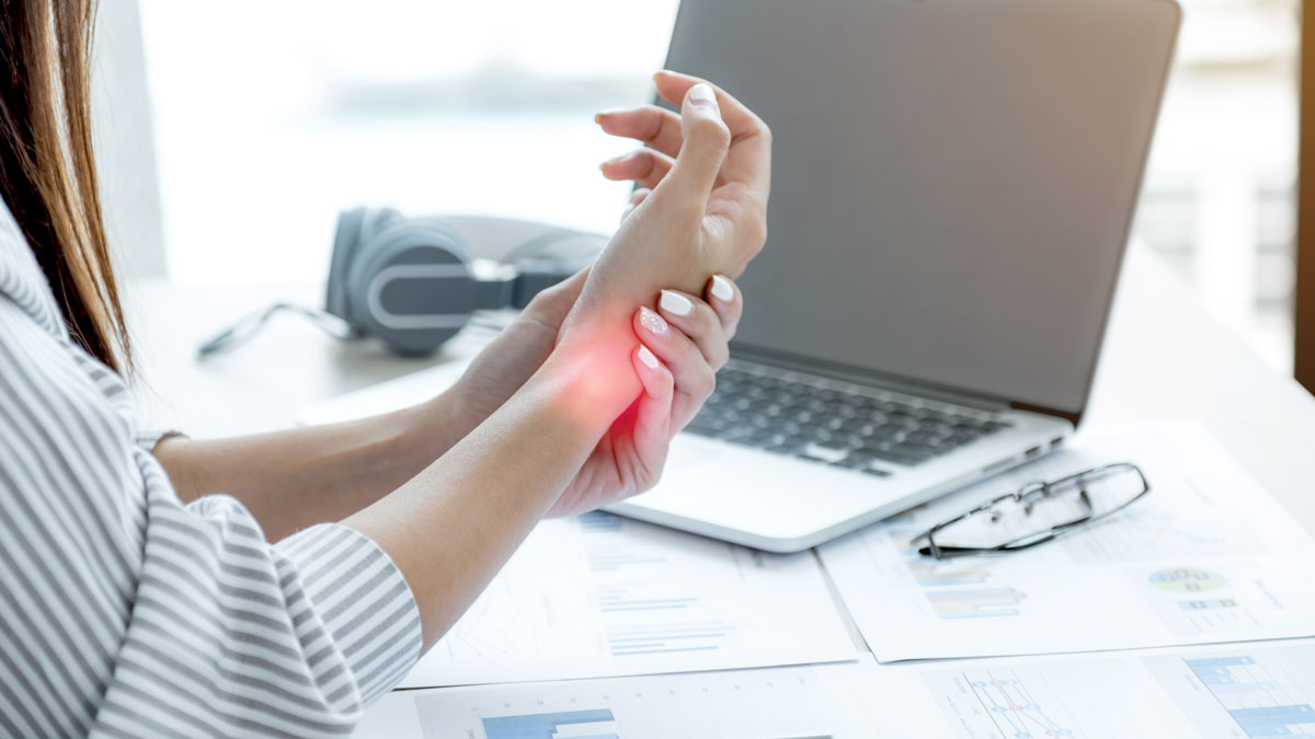 woman working at computer massaging painful wrist