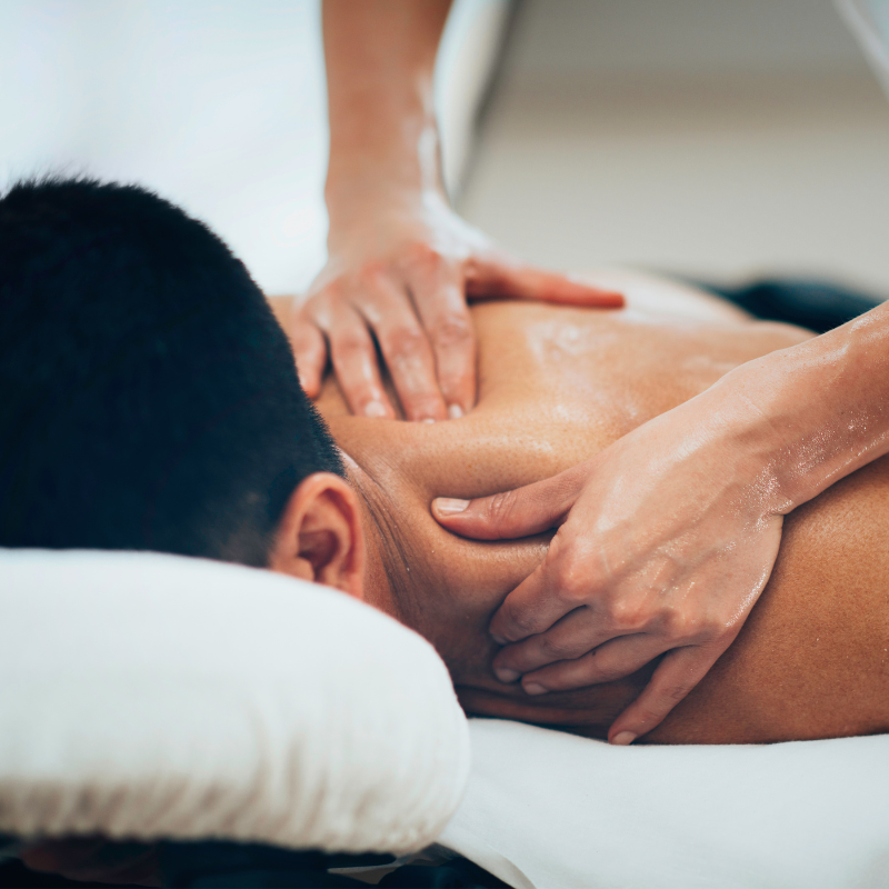 A close-up image of a client receiving a massage to the shoulder.