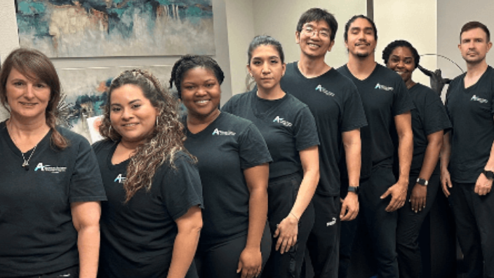 group of students posing by wall