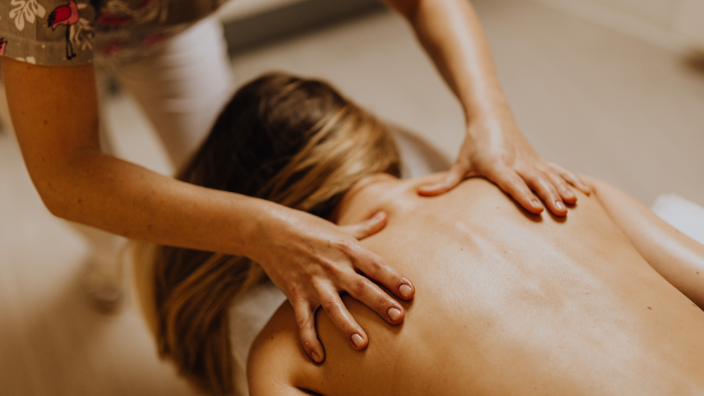 An image of a woman receiving a back massage.