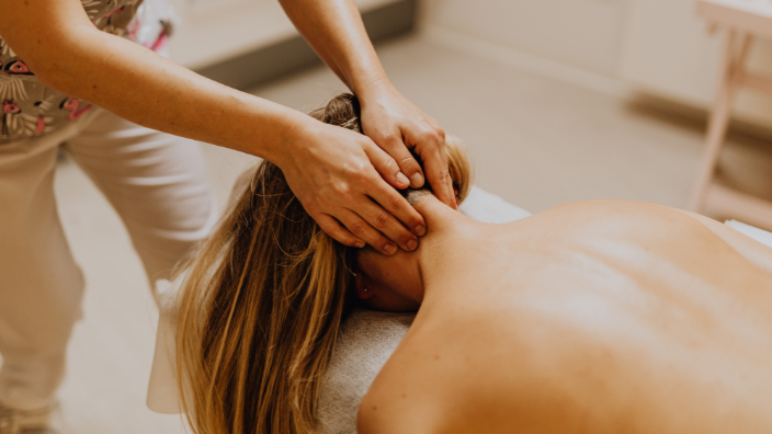 An image of a woman receiving a neck massage.