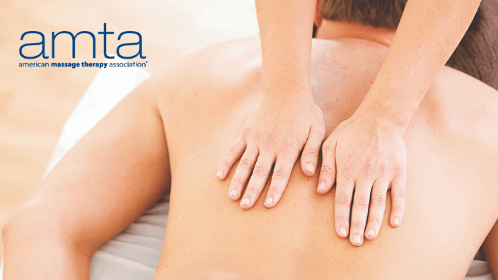 Image of a massage therapist using both hands to massage a client who is laying face down on the table, the AMTA logo is in navy font in the corner